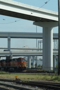 Train passing under a highway overpass